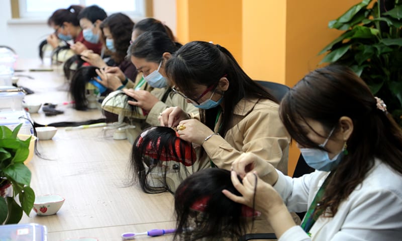 Workers produce wigs in a workshop in Northwest China's Shaanxi Province on May 16, 2021. Photo: VCG